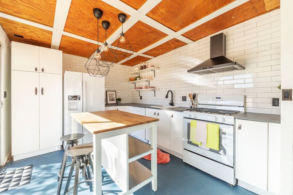 Inspiration för små moderna grått kök, med en nedsänkt diskho, släta luckor, vita skåp, vitt stänkskydd, vita vitvaror, betonggolv, en köksö, blått golv, bänkskiva i zink och stänkskydd i tunnelbanekakel