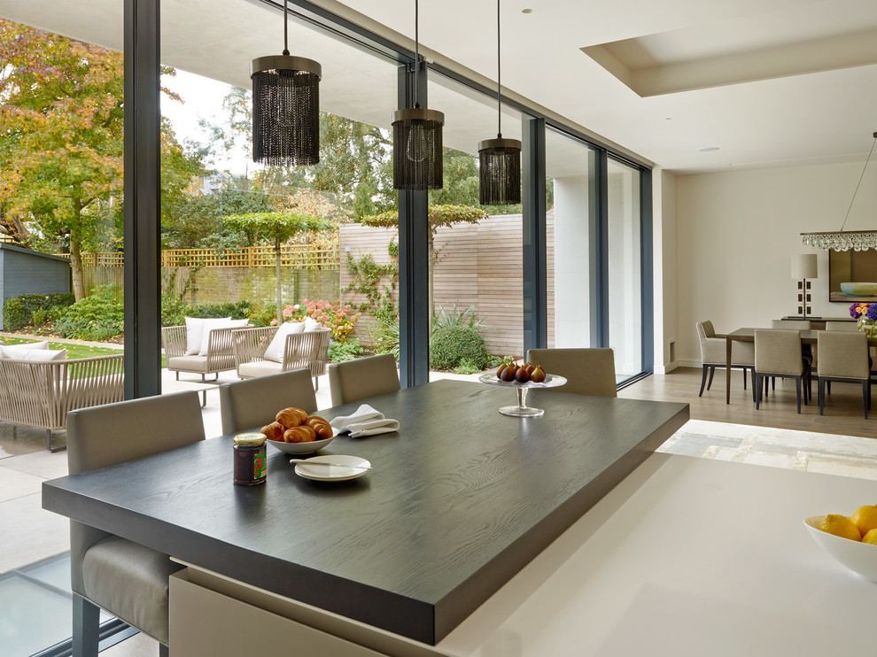 Medium sized contemporary open plan kitchen in London with an island.