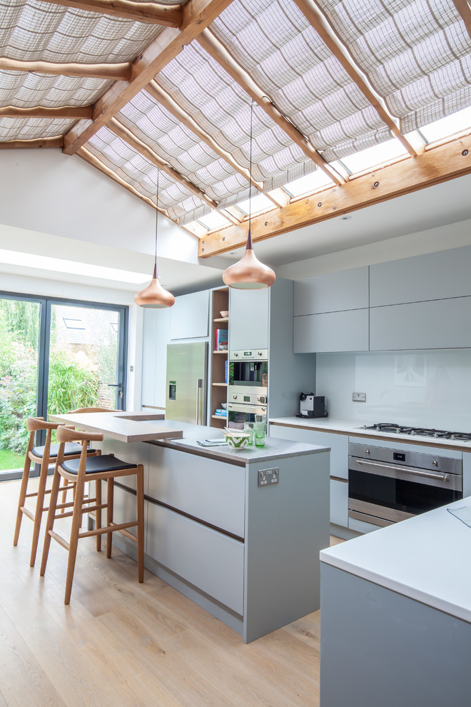 Mittelgroße Moderne Küche mit Edelstahl-Arbeitsplatte und Kücheninsel in London