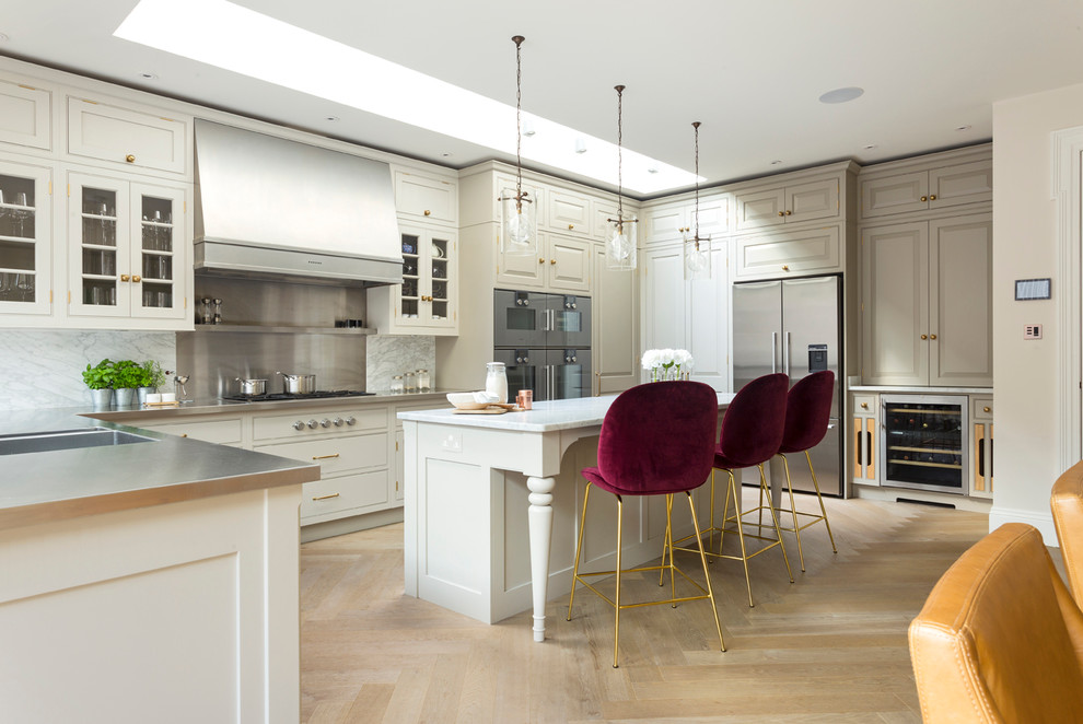 This is an example of a large classic u-shaped kitchen/diner in Hampshire with flat-panel cabinets and light hardwood flooring.