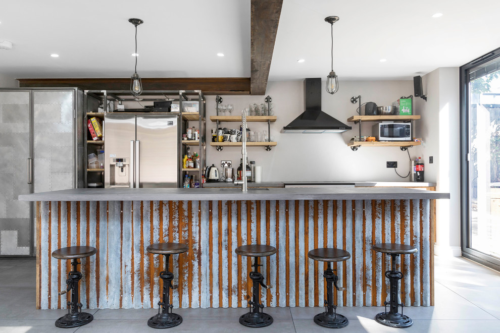 Bild på ett industriellt linjärt kök, med rostfria vitvaror och en köksö