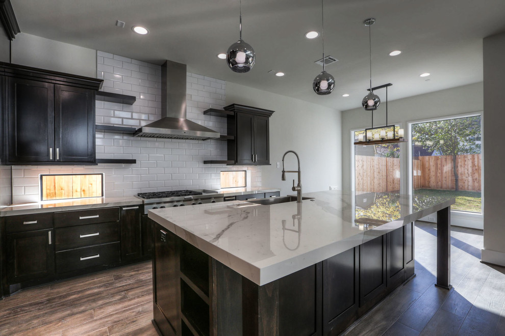 Open concept kitchen - large transitional l-shaped dark wood floor and brown floor open concept kitchen idea in Houston with a farmhouse sink, shaker cabinets, dark wood cabinets, marble countertops, white backsplash, subway tile backsplash, stainless steel appliances and an island