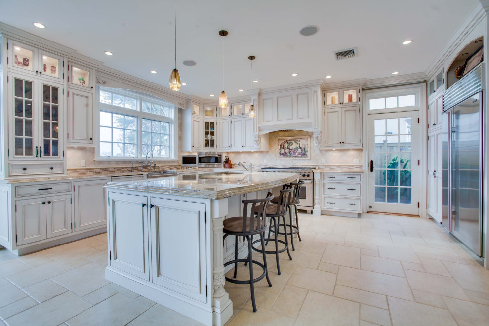 Example of a classic u-shaped beige floor kitchen design in New York with a farmhouse sink, beaded inset cabinets, beige cabinets, beige backsplash, stainless steel appliances, an island and beige countertops