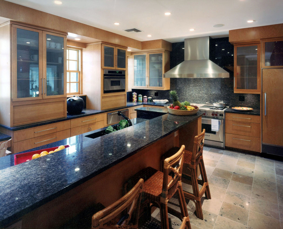 Bild på ett avskilt, stort eklektiskt grå grått u-kök, med en undermonterad diskho, släta luckor, skåp i ljust trä, granitbänkskiva, grått stänkskydd, stänkskydd i porslinskakel och en köksö
