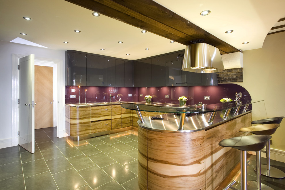 Contemporary kitchen in London with stainless steel worktops and glass sheet splashback.