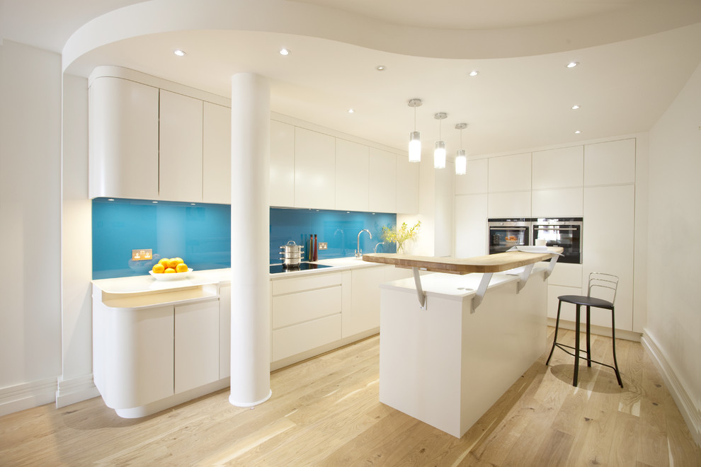 Moderne Küche mit Glasrückwand, flächenbündigen Schrankfronten und weißen Schränken in London