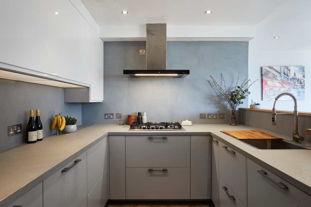 Contemporary u-shaped kitchen in London with a built-in sink, flat-panel cabinets, grey cabinets, a breakfast bar and grey worktops.