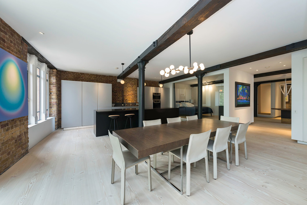 This is an example of a large urban kitchen/dining room in London with light hardwood flooring.