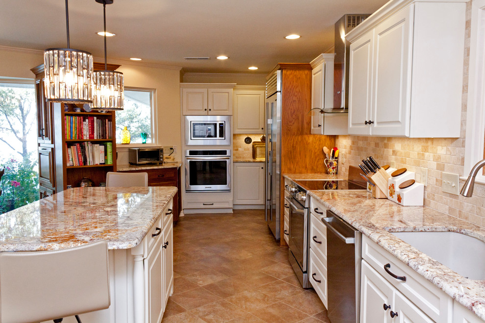 Foto på ett mellanstort amerikanskt linjärt kök och matrum, med en undermonterad diskho, luckor med upphöjd panel, vita skåp, granitbänkskiva, beige stänkskydd, stänkskydd i stenkakel, rostfria vitvaror, klinkergolv i porslin, en köksö och brunt golv