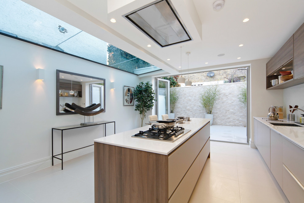 Zweizeilige Moderne Küche mit Unterbauwaschbecken, flächenbündigen Schrankfronten, hellbraunen Holzschränken, Quarzwerkstein-Arbeitsplatte, Keramikboden und Kücheninsel in London