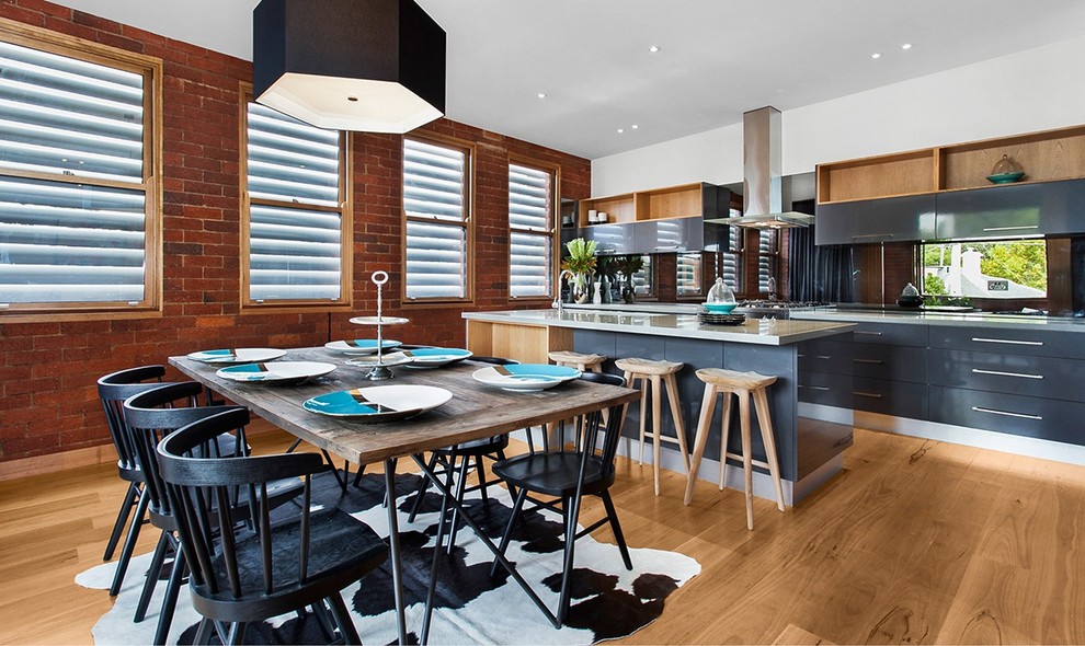 Photo of a contemporary kitchen in Melbourne with flat-panel cabinets, grey cabinets, light hardwood flooring and an island.