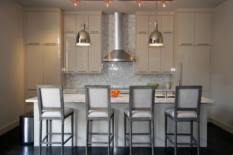 Zweizeilige Moderne Küche mit flächenbündigen Schrankfronten, beigen Schränken, Küchenrückwand in Weiß, Rückwand aus Steinfliesen und Elektrogeräten mit Frontblende in New Orleans