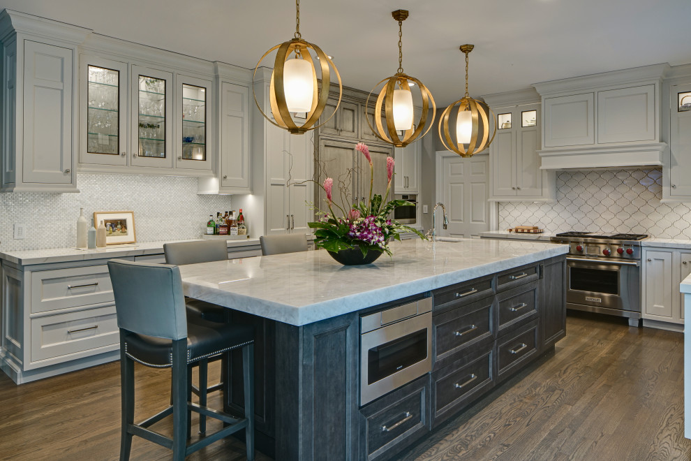 This is an example of a traditional u-shaped kitchen in Chicago with a submerged sink, beaded cabinets, grey cabinets, white splashback, stainless steel appliances, dark hardwood flooring, an island, brown floors and grey worktops.