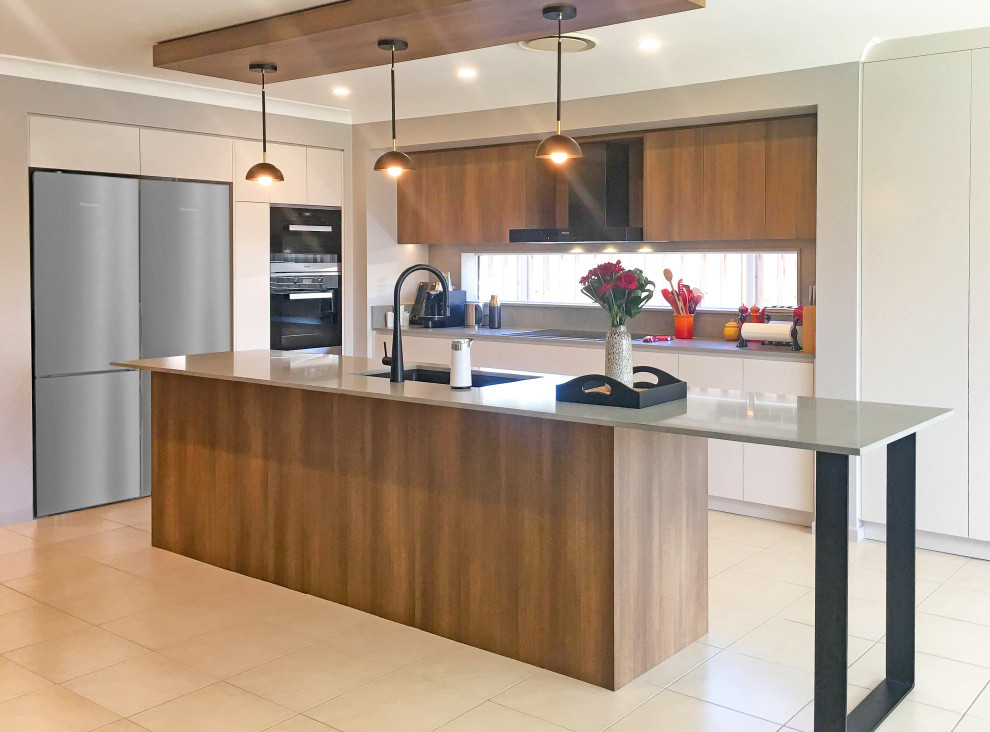 Design ideas for a medium sized contemporary l-shaped open plan kitchen with a submerged sink, flat-panel cabinets, medium wood cabinets, engineered stone countertops, grey splashback, black appliances, ceramic flooring, an island, multi-coloured floors and grey worktops.