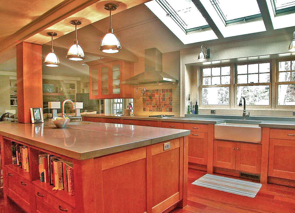 Bild på ett stort amerikanskt grå grått kök, med en rustik diskho, luckor med infälld panel, skåp i mellenmörkt trä, bänkskiva i betong, grått stänkskydd, stänkskydd i keramik, rostfria vitvaror, mellanmörkt trägolv, en köksö och brunt golv