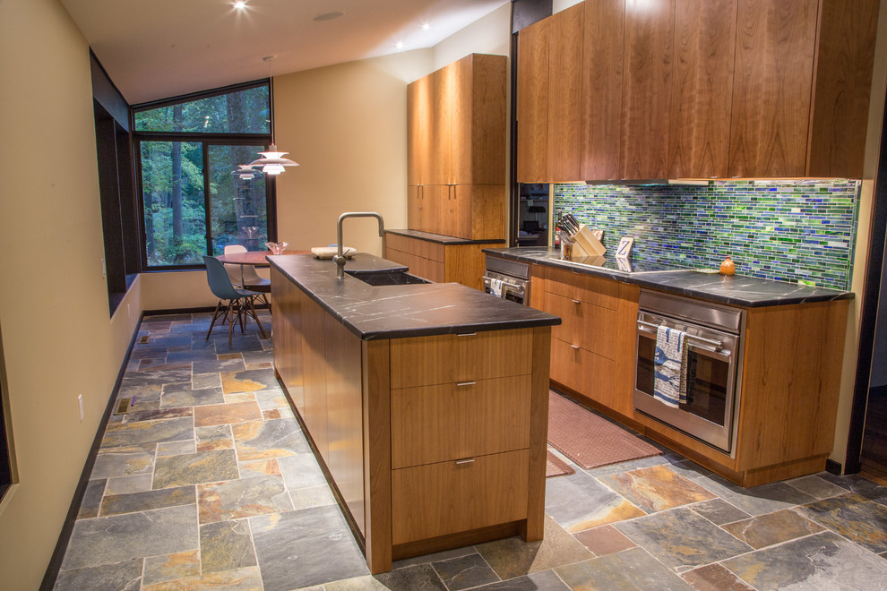 Exempel på ett mellanstort modernt kök, med en rustik diskho, släta luckor, skåp i ljust trä, bänkskiva i täljsten, flerfärgad stänkskydd, stänkskydd i glaskakel, rostfria vitvaror, skiffergolv och en köksö