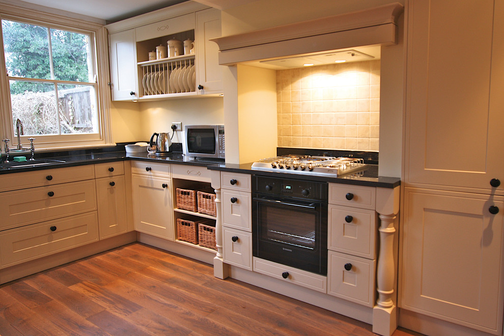 Foto de cocina campestre con puertas de armario beige, suelo de madera en tonos medios y encimera de granito