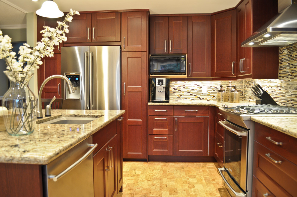 Inredning av ett klassiskt mellanstort kök, med en undermonterad diskho, luckor med infälld panel, röda skåp, bänkskiva i kvarts, flerfärgad stänkskydd, stänkskydd i stickkakel, rostfria vitvaror, korkgolv och en köksö
