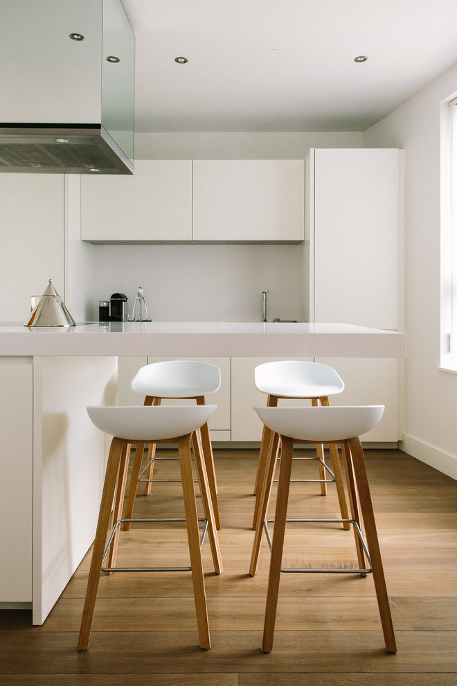 Esempio di una cucina design con ante lisce, ante bianche, paraspruzzi bianco e pavimento in legno massello medio