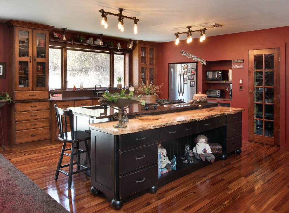 Inspiration för ett stort lantligt brun linjärt brunt kök, med en undermonterad diskho, släta luckor, skåp i mellenmörkt trä, granitbänkskiva, rostfria vitvaror, mellanmörkt trägolv, en köksö och brunt golv