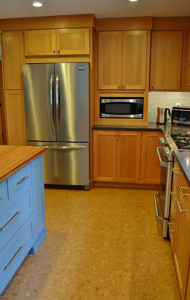 Esempio di una grande cucina con lavello sottopiano, ante in stile shaker, ante in legno chiaro, top in superficie solida, paraspruzzi blu, paraspruzzi con piastrelle di vetro, elettrodomestici in acciaio inossidabile e pavimento in sughero