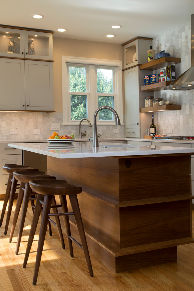 Modern inredning av ett stort vit vitt kök, med en enkel diskho, skåp i shakerstil, grå skåp, bänkskiva i kvarts, grått stänkskydd, stänkskydd i marmor, rostfria vitvaror, mellanmörkt trägolv, en köksö och orange golv