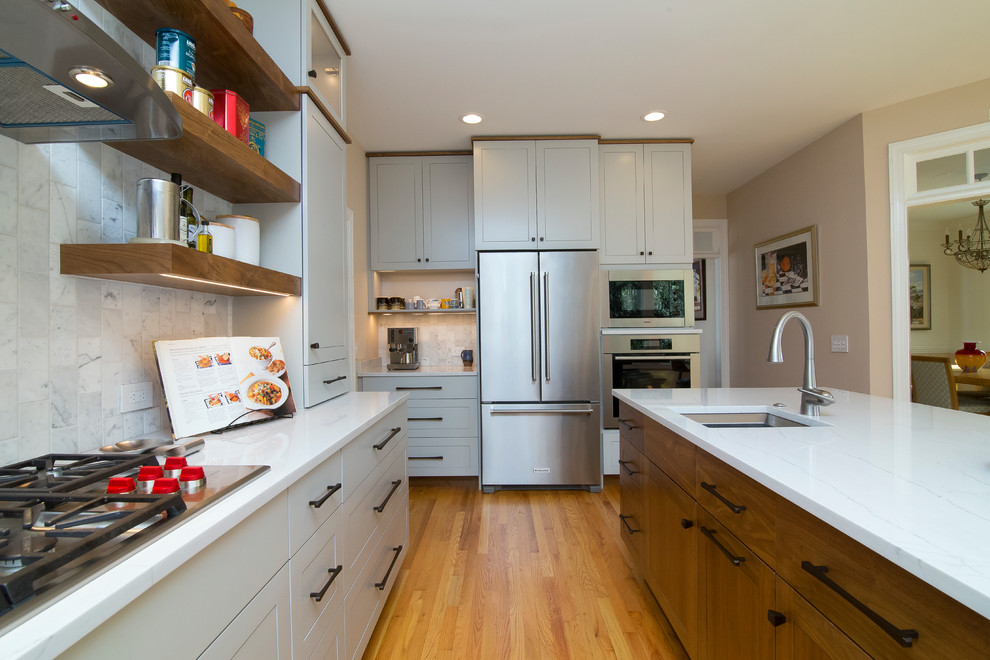 Inspiration for a large contemporary l-shaped medium tone wood floor and orange floor eat-in kitchen remodel in Raleigh with a single-bowl sink, shaker cabinets, gray cabinets, quartz countertops, gray backsplash, marble backsplash, stainless steel appliances, an island and white countertops