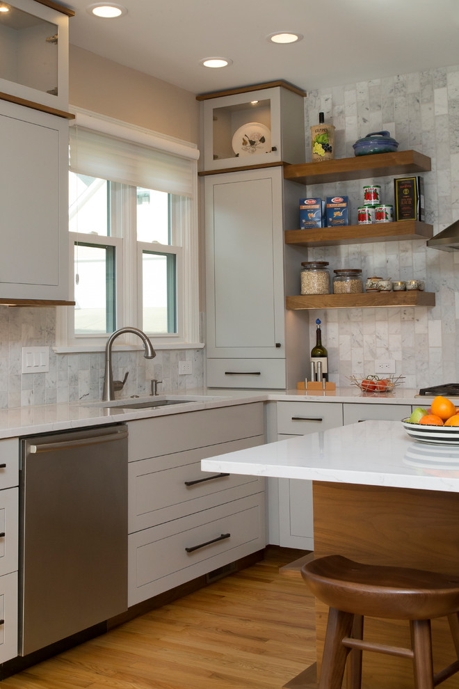 Example of a large trendy l-shaped medium tone wood floor and orange floor eat-in kitchen design in Raleigh with a single-bowl sink, shaker cabinets, gray cabinets, quartz countertops, gray backsplash, marble backsplash, stainless steel appliances, an island and white countertops