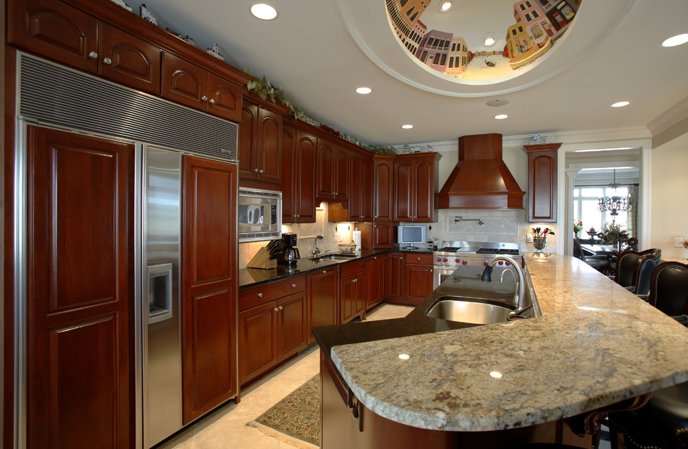 Inspiration for a mid-sized timeless l-shaped enclosed kitchen remodel in Cincinnati with an undermount sink, raised-panel cabinets, medium tone wood cabinets, granite countertops, beige backsplash, stainless steel appliances and an island
