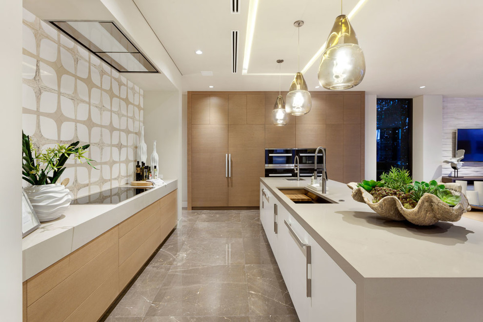 Immagine di una grande cucina minimalista con lavello sottopiano, ante lisce, ante in legno chiaro, top in quarzite, paraspruzzi bianco, elettrodomestici da incasso e pavimento in marmo