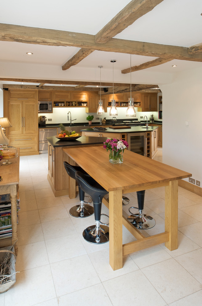 This is an example of a large rural l-shaped kitchen/diner in Sussex with shaker cabinets, medium wood cabinets, quartz worktops, black splashback, integrated appliances, ceramic flooring and multiple islands.