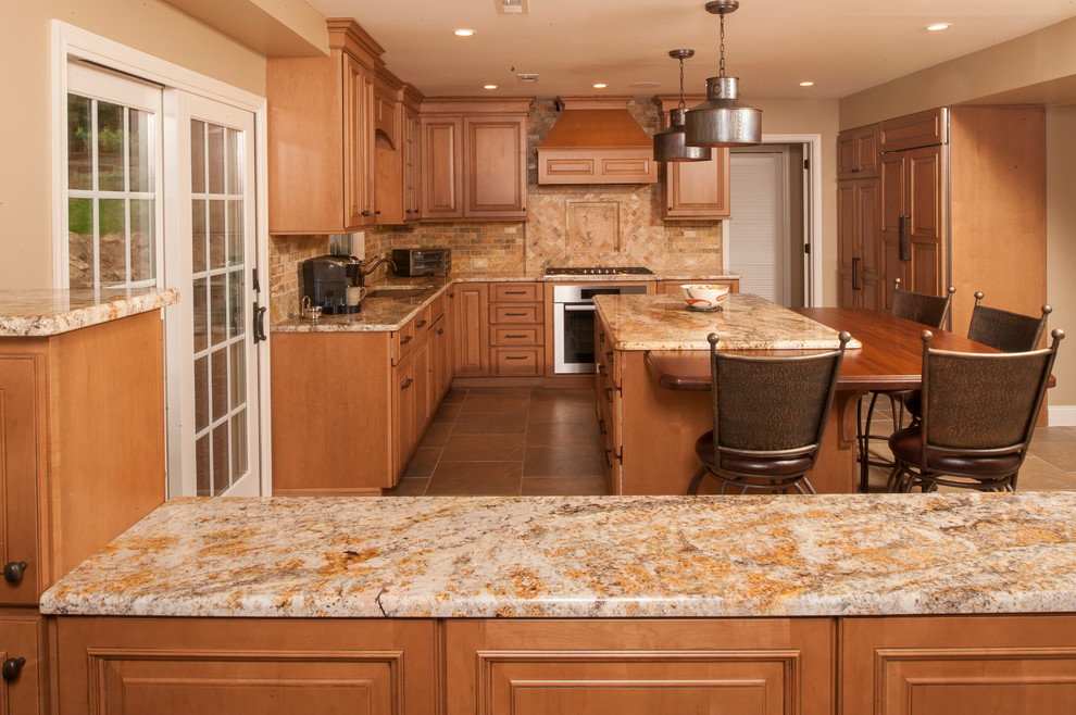 Inspiration for a mid-sized timeless l-shaped porcelain tile open concept kitchen remodel in Philadelphia with an undermount sink, raised-panel cabinets, medium tone wood cabinets, granite countertops, multicolored backsplash, stone tile backsplash, paneled appliances and an island
