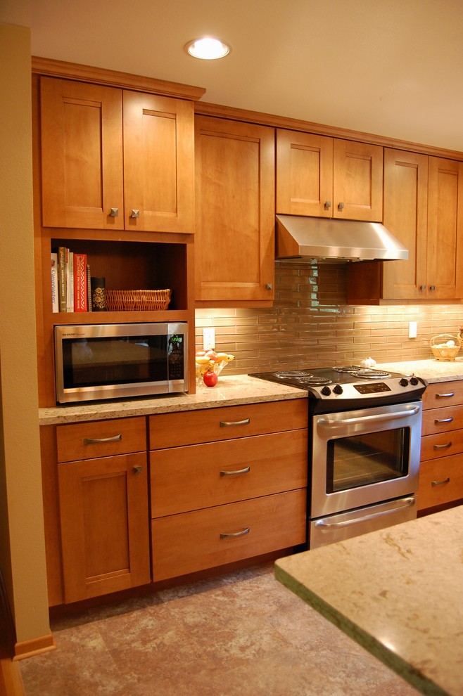 Exempel på ett mellanstort klassiskt flerfärgad flerfärgat kök, med en undermonterad diskho, skåp i shakerstil, skåp i mellenmörkt trä, bänkskiva i kvarts, brunt stänkskydd, stänkskydd i glaskakel, rostfria vitvaror, en halv köksö och laminatgolv