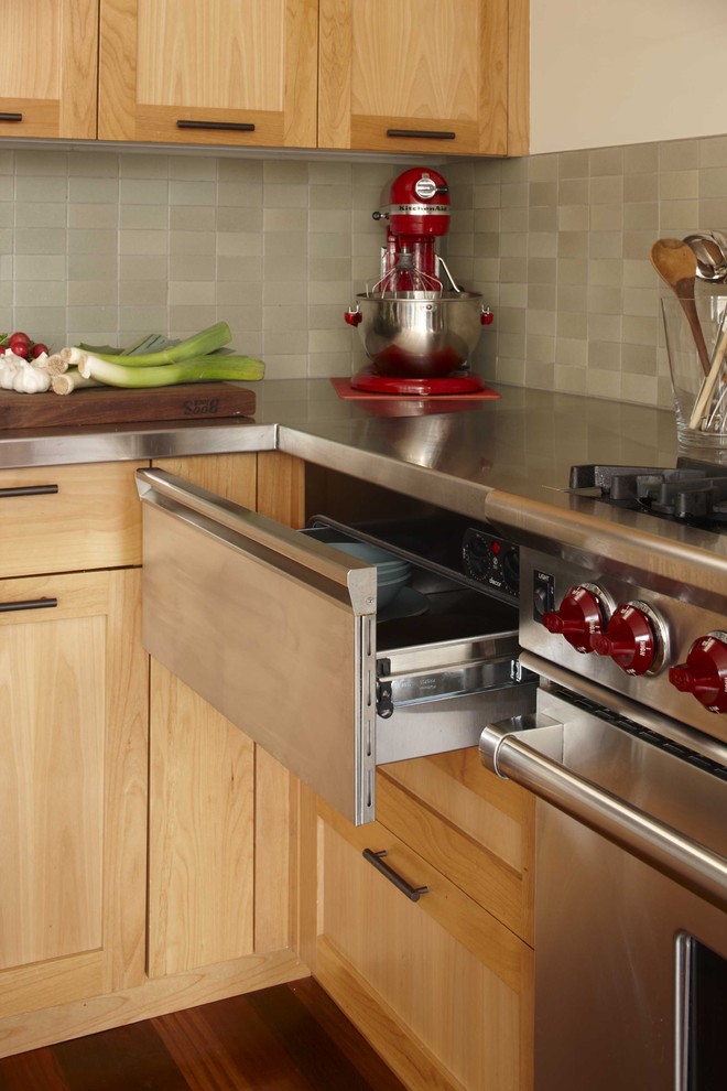 Cette photo montre une cuisine chic en bois brun avec un électroménager en acier inoxydable, un plan de travail en inox et un placard à porte shaker.