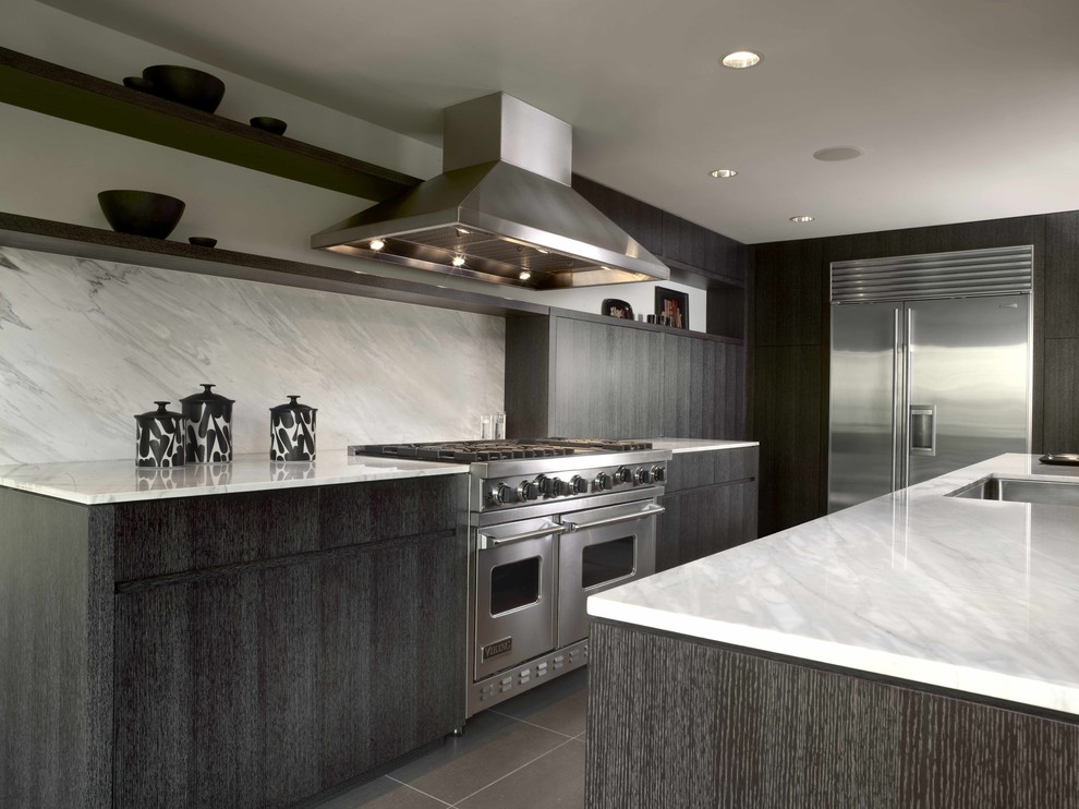 Moderne Küche mit Küchengeräten aus Edelstahl, Marmor-Arbeitsplatte, Unterbauwaschbecken, flächenbündigen Schrankfronten, schwarzen Schränken, Küchenrückwand in Weiß und Rückwand aus Stein in Seattle