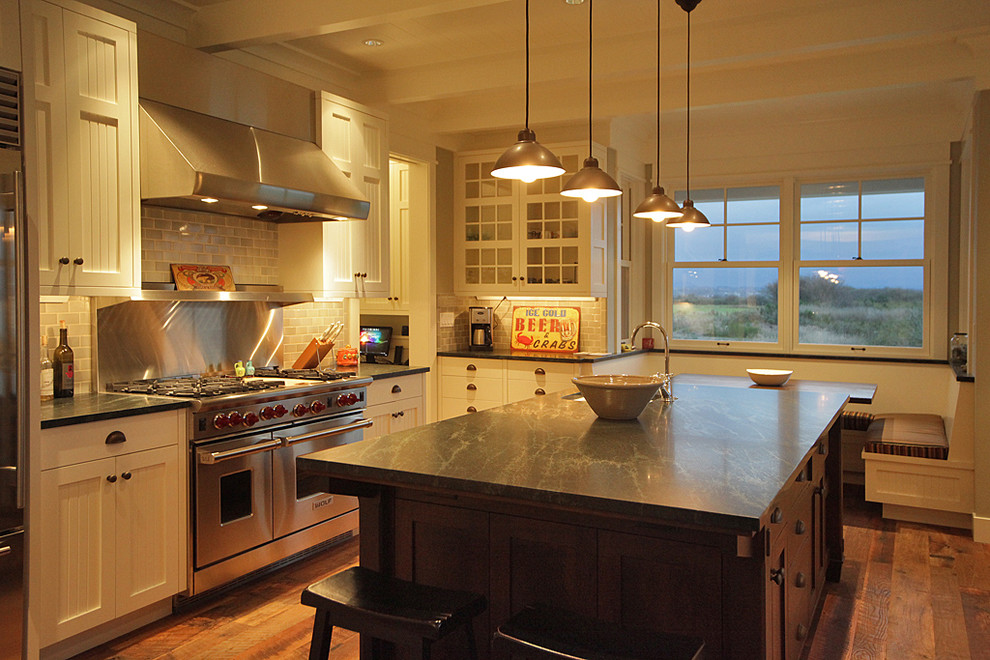 Example of a classic kitchen design in Seattle with glass-front cabinets, stainless steel appliances, white cabinets and soapstone countertops