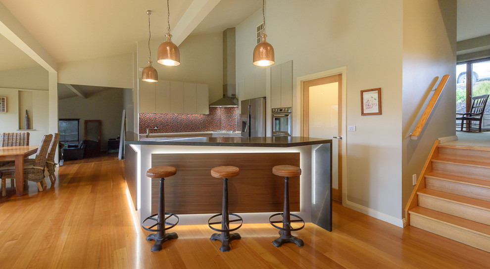 Idéer för ett mellanstort modernt kök med öppen planlösning, med en dubbel diskho, släta luckor, bänkskiva i kvarts, rött stänkskydd, stänkskydd i mosaik, rostfria vitvaror, mellanmörkt trägolv, en köksö och brunt golv