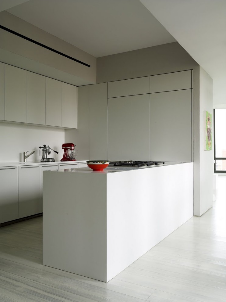 На фото: кухня в стиле модернизм с плоскими фасадами, белыми фасадами и белым полом