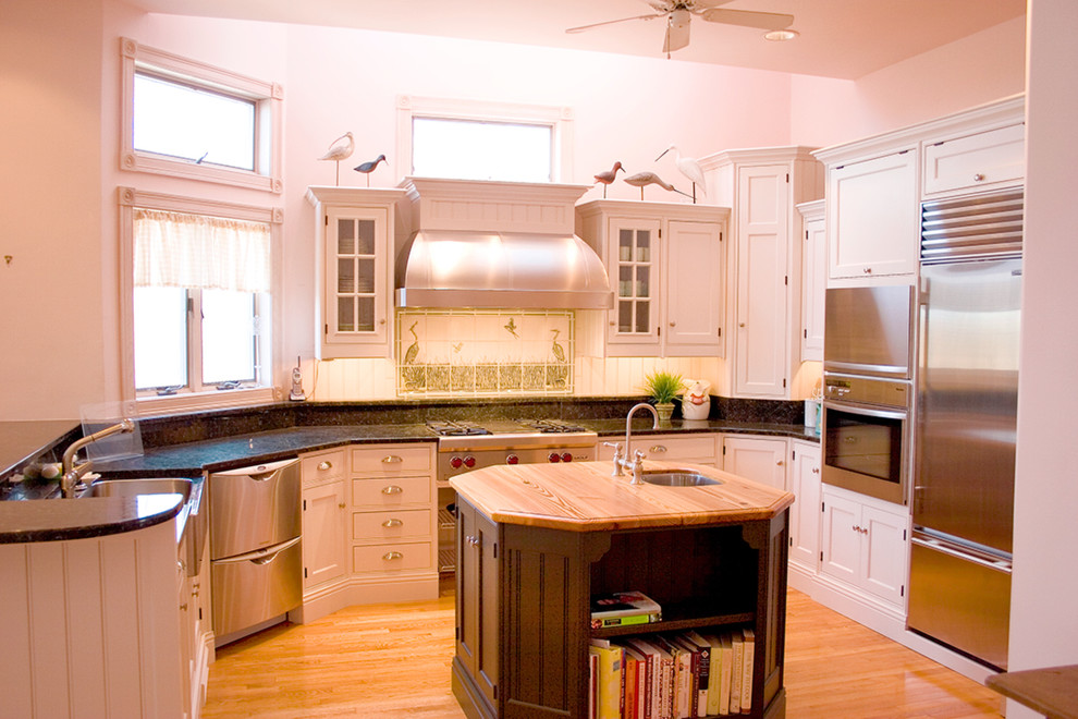 Esempio di una cucina stile marinaro con lavello stile country, ante a filo, ante bianche, top in granito e elettrodomestici in acciaio inossidabile