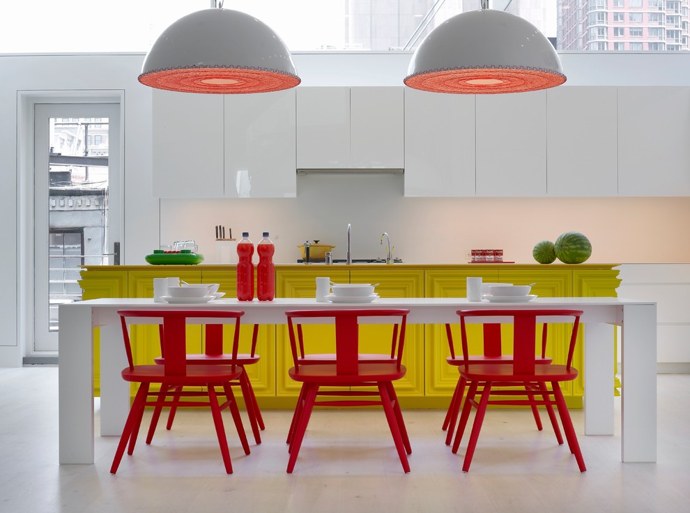 Trendy white floor eat-in kitchen photo in New York with recessed-panel cabinets, yellow cabinets and white backsplash