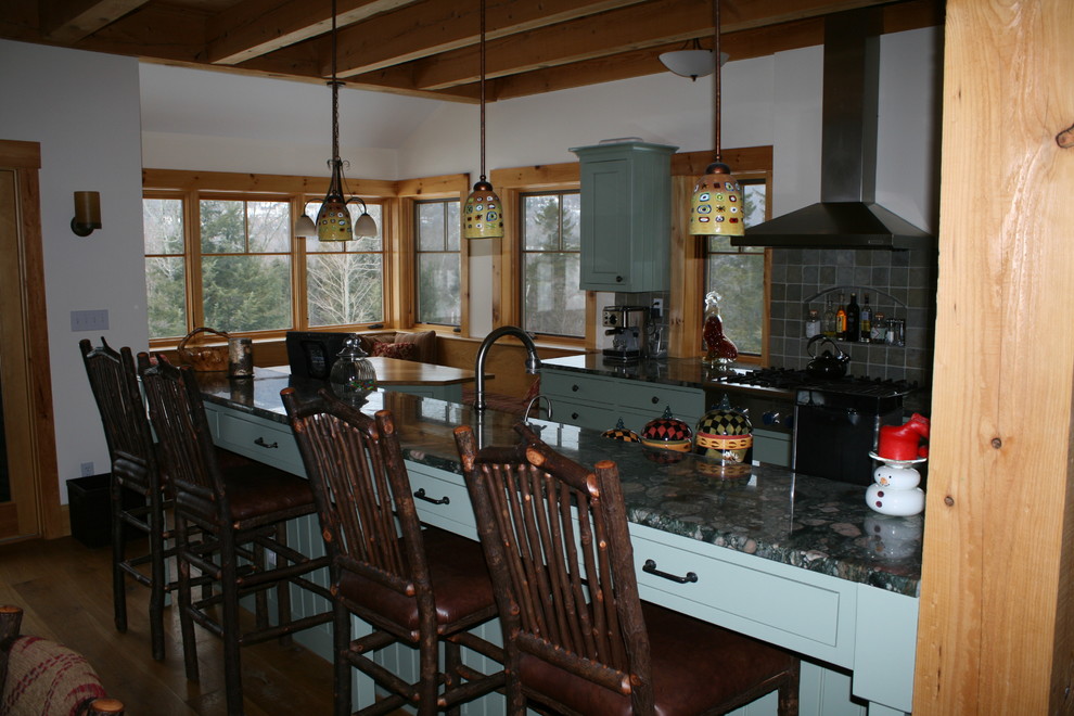 Inspiration for a large rustic galley medium tone wood floor and brown floor eat-in kitchen remodel in Burlington with an undermount sink, flat-panel cabinets, green cabinets, granite countertops, multicolored backsplash, stone tile backsplash, stainless steel appliances and an island