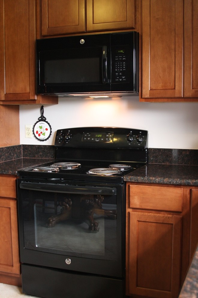 ワシントンD.C.にあるお手頃価格の小さなトラディショナルスタイルのおしゃれなキッチン (黒い調理設備、中間色木目調キャビネット、アイランドなし) の写真