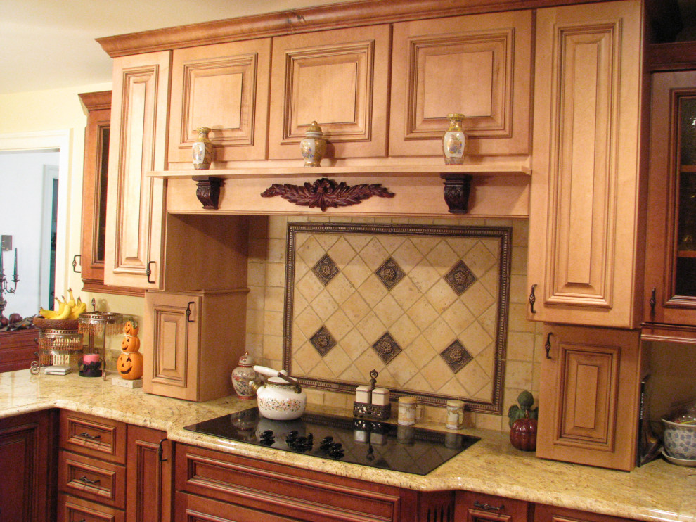 Foto di una cucina classica di medie dimensioni con ante marroni, top in granito, paraspruzzi beige, paraspruzzi in gres porcellanato, elettrodomestici neri, parquet chiaro, pavimento marrone e top beige