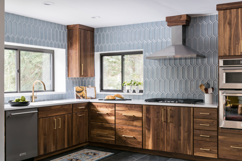 Medium sized contemporary l-shaped kitchen/diner in St Louis with a single-bowl sink, flat-panel cabinets, medium wood cabinets, engineered stone countertops, blue splashback, porcelain splashback, stainless steel appliances, slate flooring, no island, black floors and white worktops.