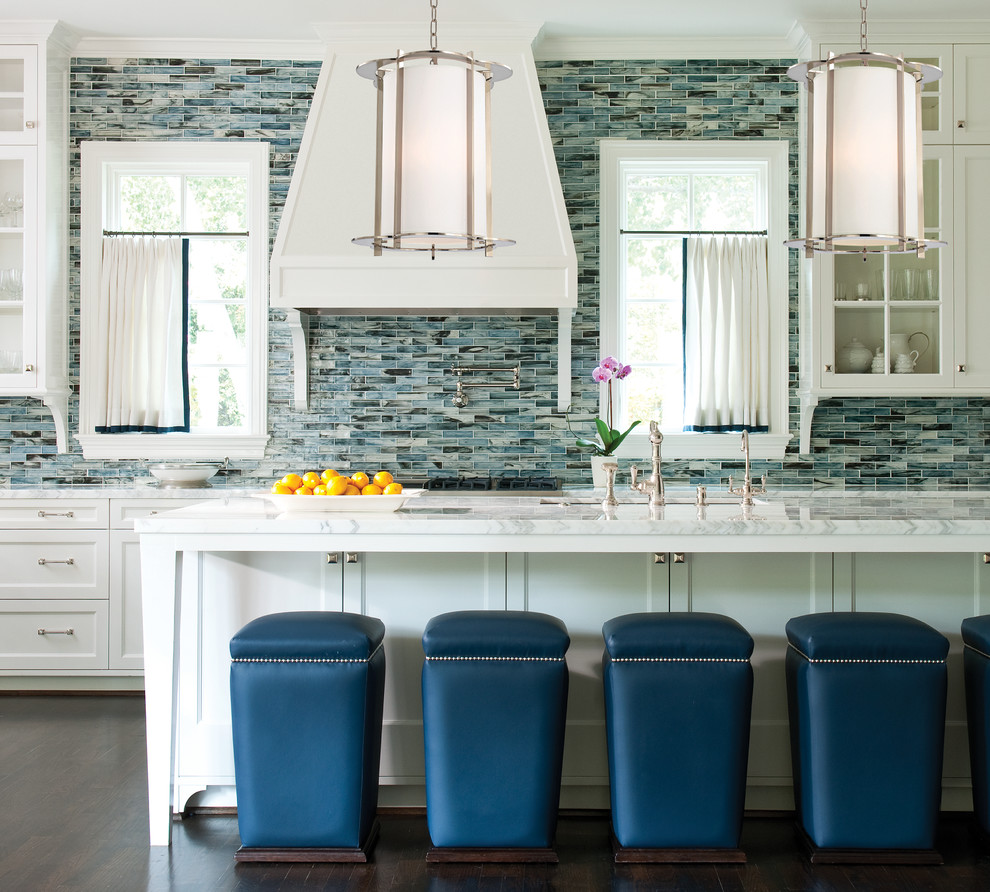 На фото: кухня в стиле неоклассика (современная классика) с стеклянными фасадами, белыми фасадами, синим фартуком, фартуком из плитки мозаики, темным паркетным полом, островом и окном с