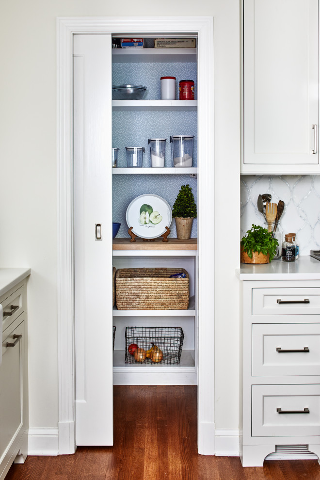 Bild på ett mellanstort vintage vit vitt kök, med en rustik diskho, luckor med infälld panel, blå skåp, bänkskiva i kvarts, vitt stänkskydd, stänkskydd i marmor, integrerade vitvaror, mellanmörkt trägolv, en köksö och brunt golv