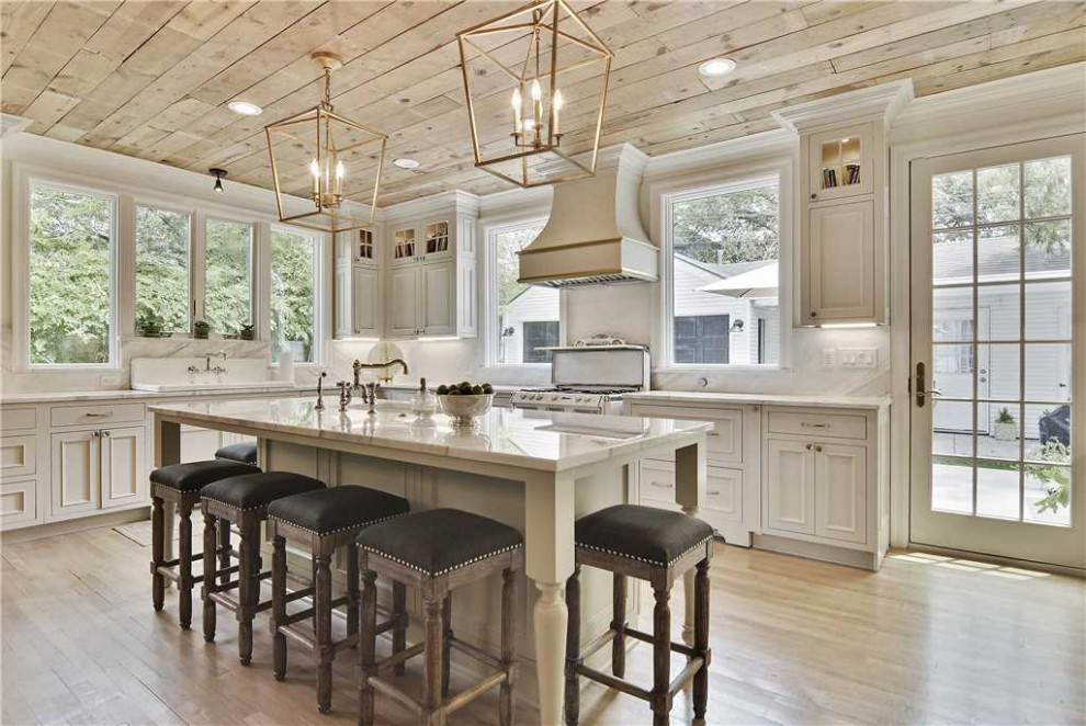 Inspiration for a large timeless u-shaped light wood floor, brown floor and wood ceiling eat-in kitchen remodel in Austin with a drop-in sink, recessed-panel cabinets, white cabinets and an island