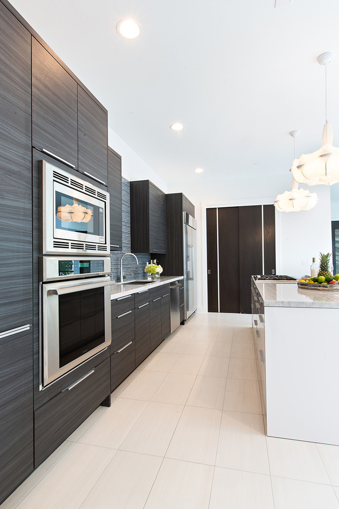 Cette image montre une cuisine parallèle design avec un placard à porte plane, des portes de placard noires, un électroménager en acier inoxydable et îlot.