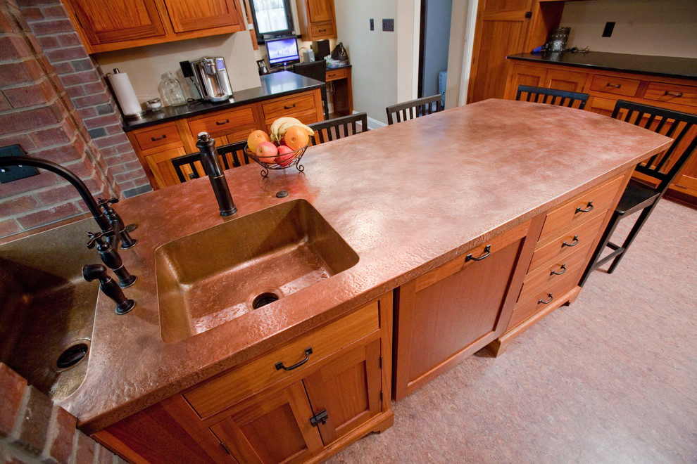 Eat-in kitchen - mediterranean eat-in kitchen idea in Indianapolis with a drop-in sink, recessed-panel cabinets, brown cabinets, quartz countertops and gray backsplash