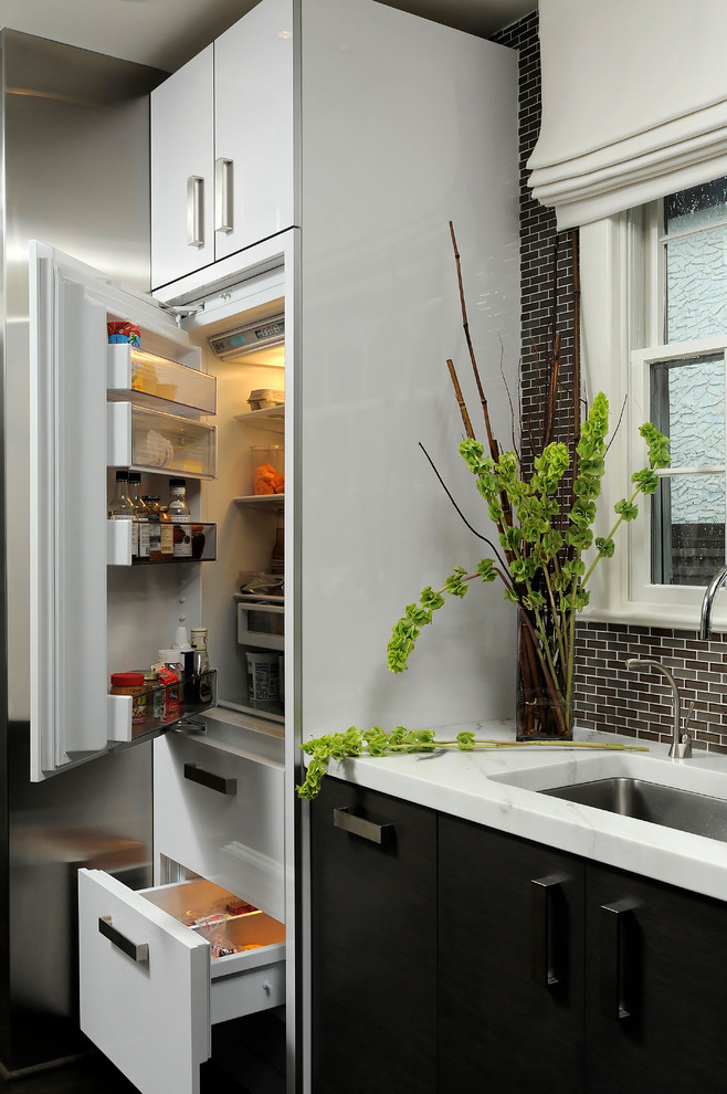 Idéer för ett mellanstort modernt kök, med en undermonterad diskho, släta luckor, svarta skåp, granitbänkskiva, flerfärgad stänkskydd, stänkskydd i glaskakel, rostfria vitvaror, mellanmörkt trägolv och en halv köksö
